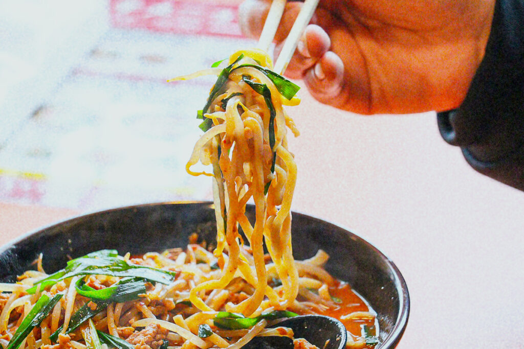 ラーメンを箸で持ち上げる様子